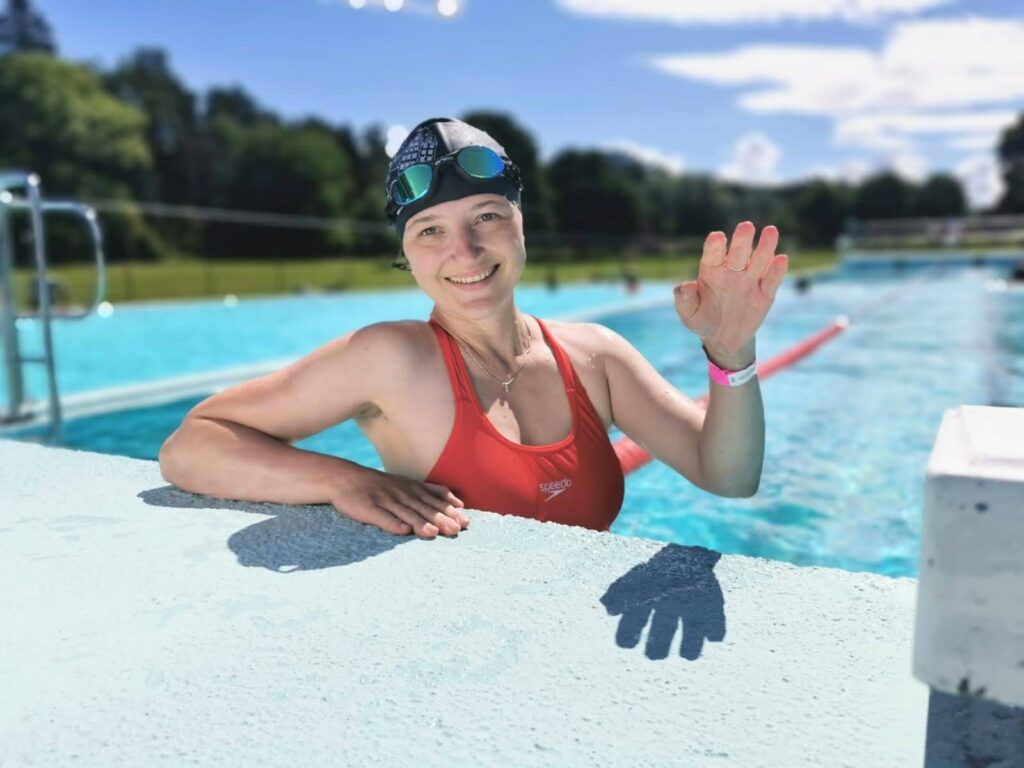 Oxana waving in outdoor pool